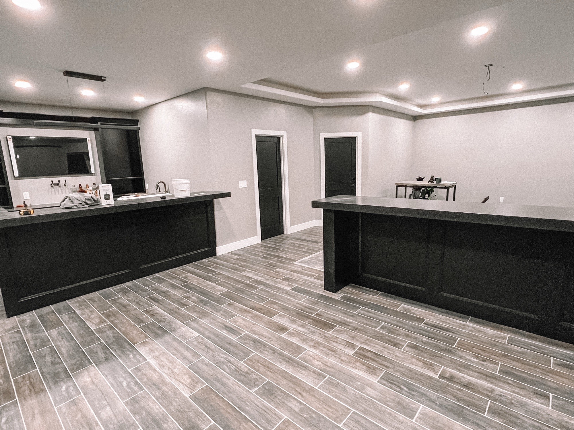Custom basement bar cabinetry with dark wood paneling