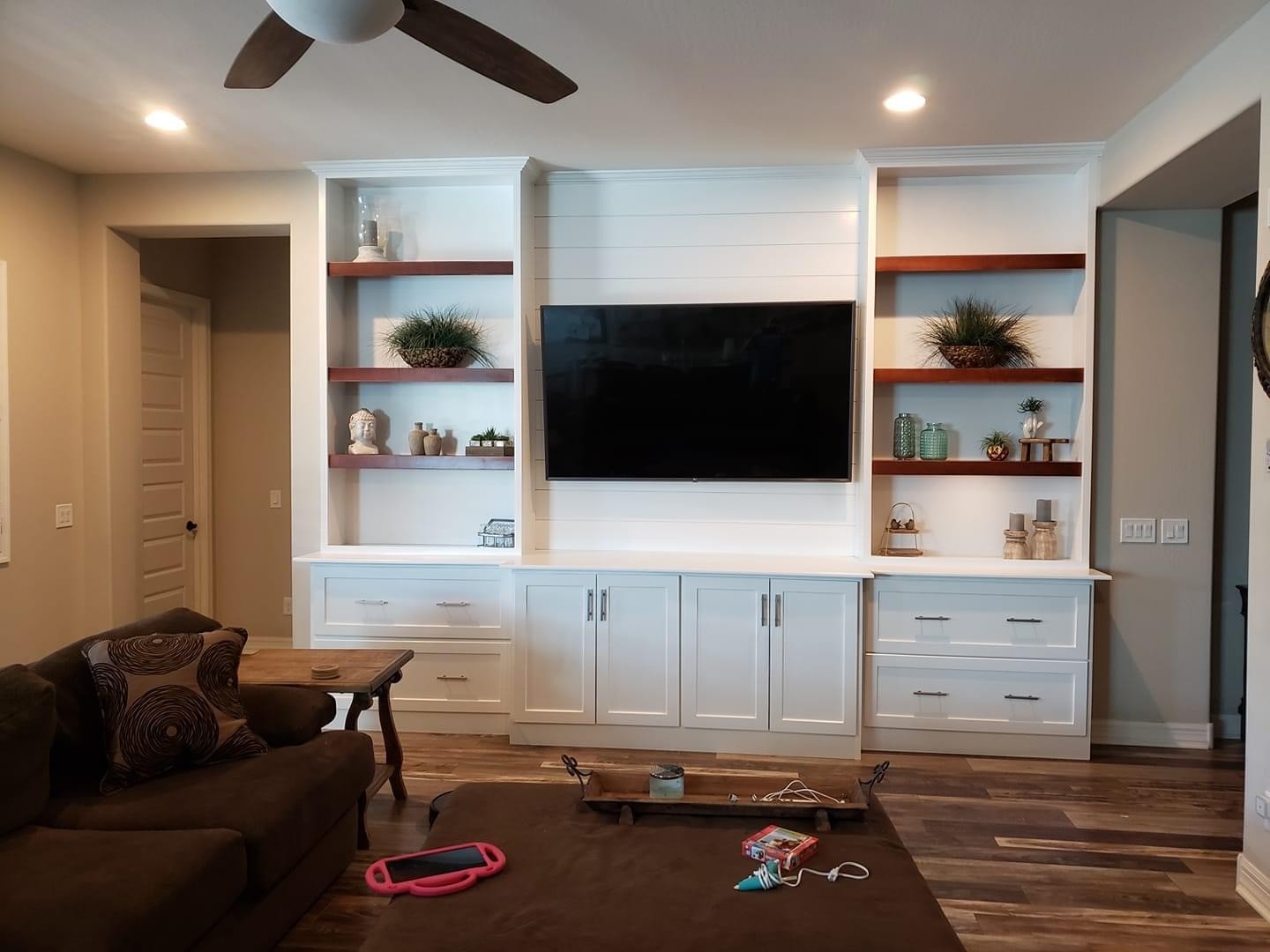 Built-in shelving flanking a shiplap media center
