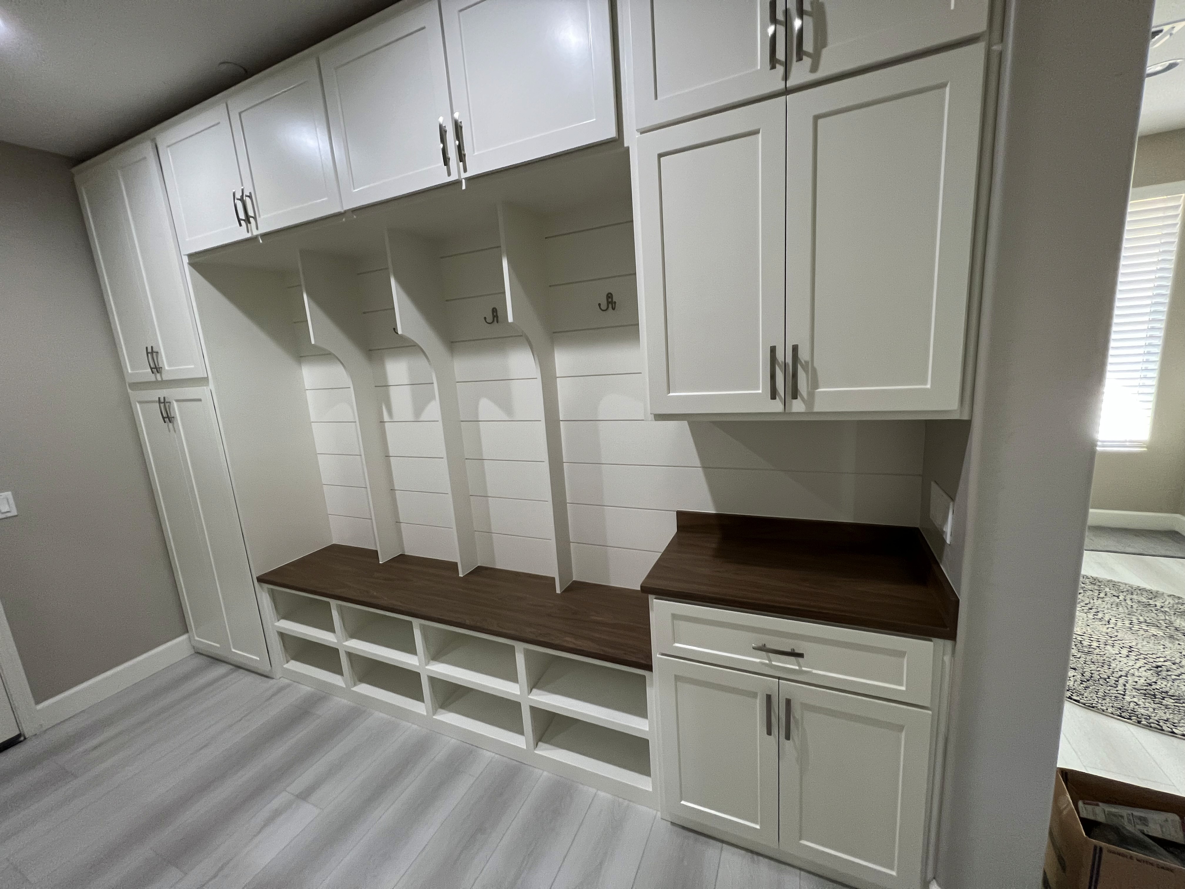 Mudroom bench with cubbies, hooks, and shiplap backing