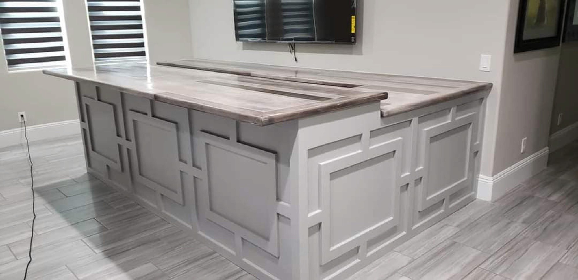 Custom cabinetry island with a waterfall wood countertop